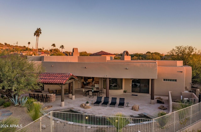 back house at dusk with a patio