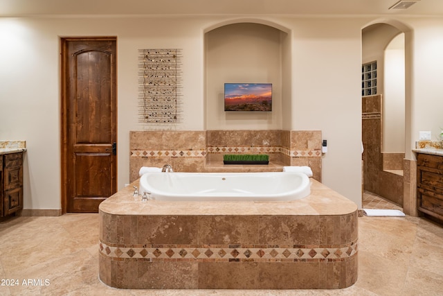 bathroom with tiled bath and vanity