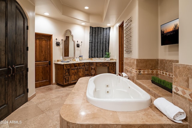 bathroom with tiled bath and vanity