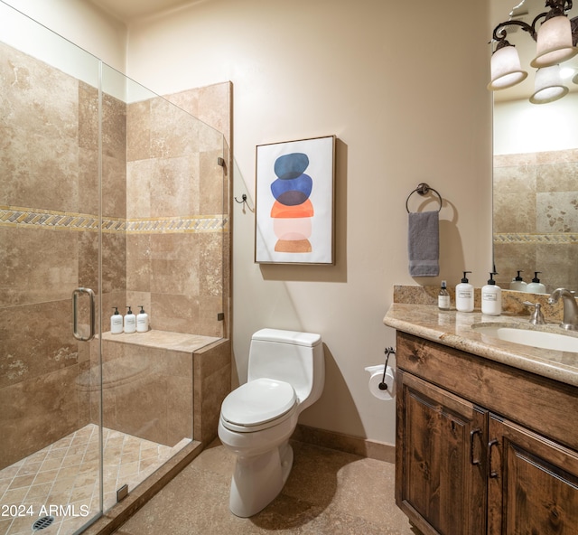 bathroom with toilet, vanity, and a shower with door