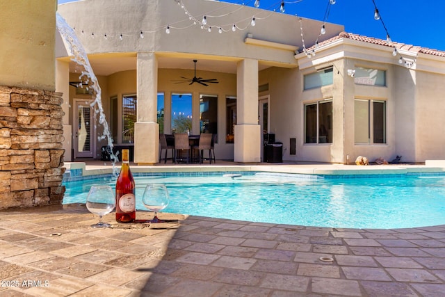 outdoor pool featuring a patio area and a ceiling fan