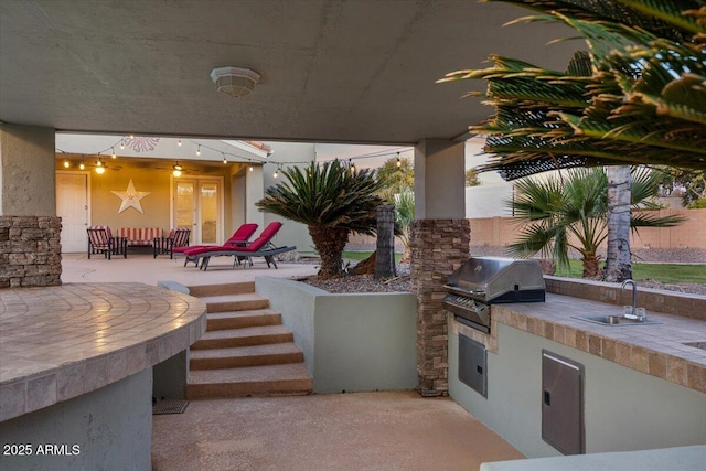 view of patio / terrace featuring exterior kitchen, french doors, a grill, and a sink