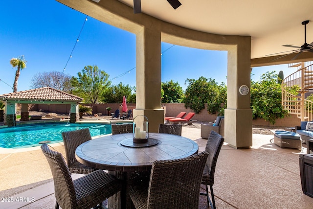 view of patio with a fenced in pool, outdoor dining area, a gazebo, a ceiling fan, and a fenced backyard