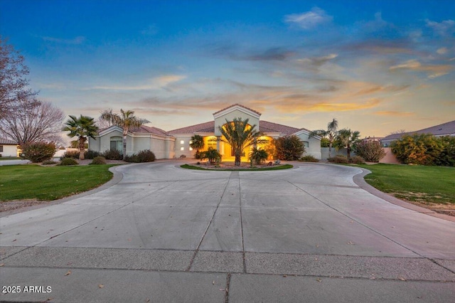 view of front facade with curved driveway and a front lawn