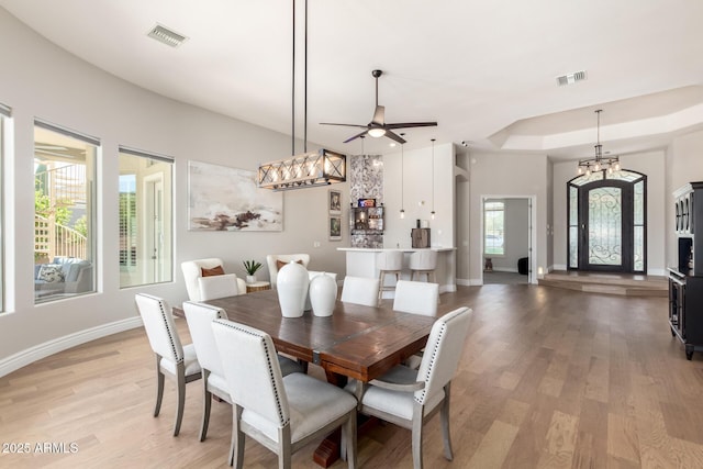 dining room featuring a wealth of natural light, baseboards, visible vents, and light wood finished floors