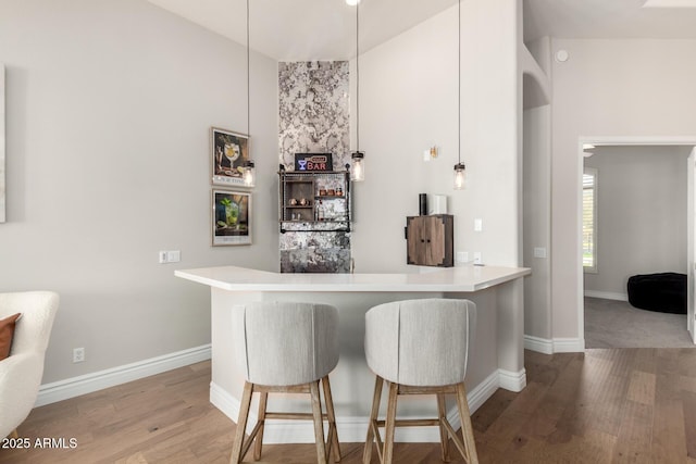 bar featuring a dry bar, wood finished floors, and baseboards