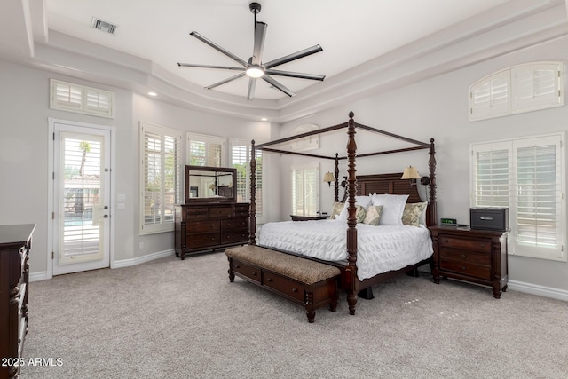 carpeted bedroom with access to outside, a raised ceiling, and baseboards