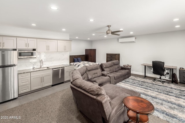 living area with ceiling fan, a wall mounted AC, baseboards, and recessed lighting