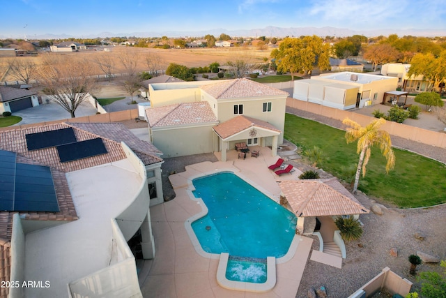 view of pool with a yard, a pool with connected hot tub, a fenced backyard, and a patio