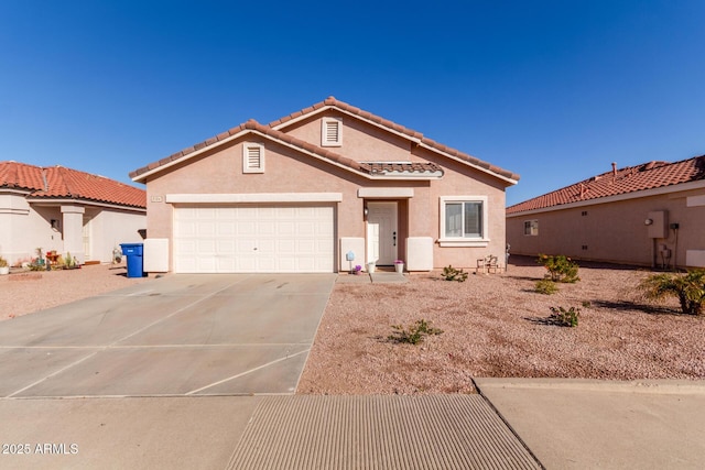 mediterranean / spanish-style home featuring a garage, driveway, a tile roof, and stucco siding