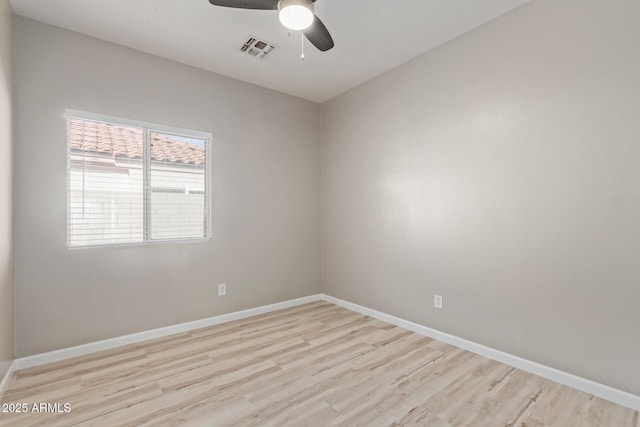 empty room with ceiling fan, light wood-style floors, visible vents, and baseboards