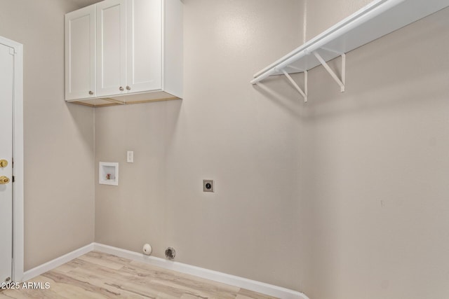 laundry area featuring hookup for a washing machine, light wood-style flooring, hookup for an electric dryer, baseboards, and cabinet space