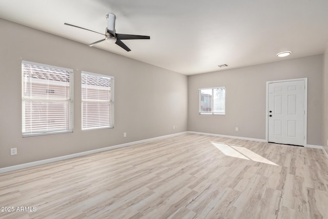 unfurnished room featuring ceiling fan, light wood finished floors, visible vents, and baseboards