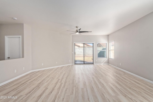 spare room featuring light wood finished floors, ceiling fan, and baseboards