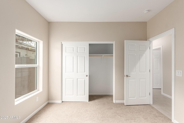 unfurnished bedroom featuring a closet and light carpet