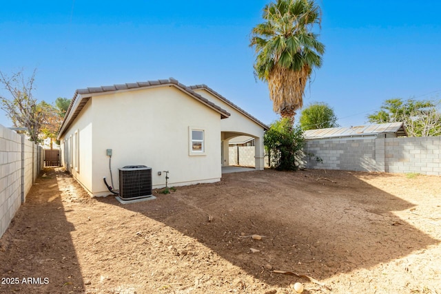 back of house featuring a carport and central air condition unit