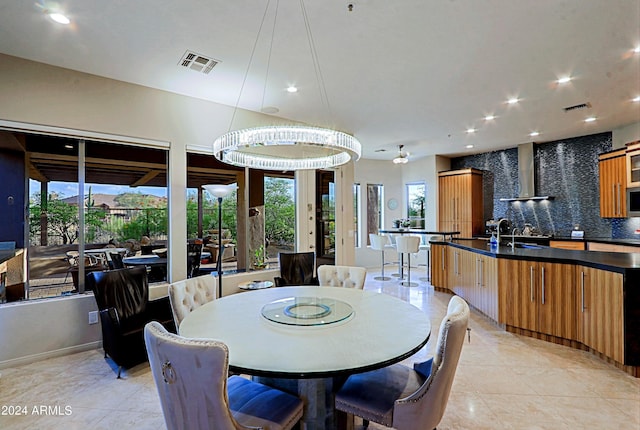 dining room with sink, light tile patterned flooring, and a notable chandelier