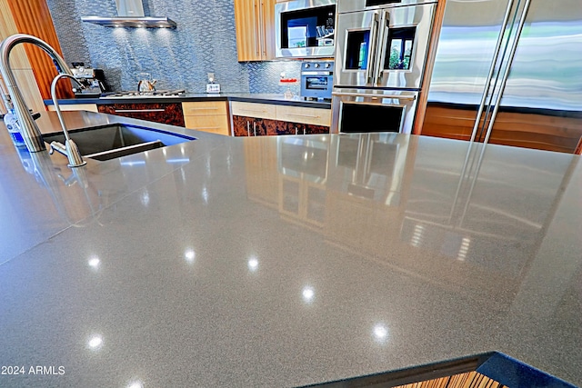 kitchen featuring light brown cabinets, sink, decorative backsplash, stainless steel appliances, and extractor fan