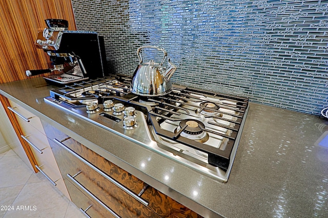 interior details featuring stainless steel gas stovetop and decorative backsplash