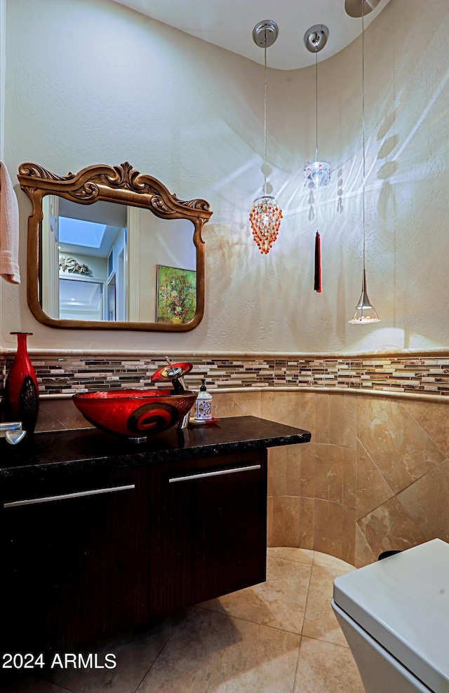 bathroom with tile patterned flooring, vanity, and tile walls