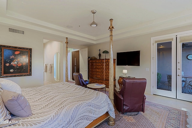 bedroom with access to exterior, french doors, and a raised ceiling