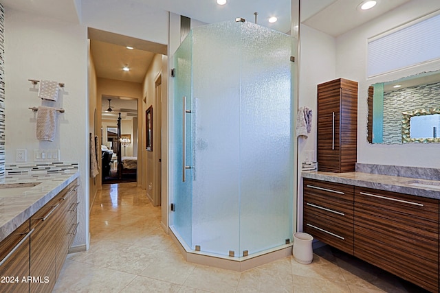 bathroom with tile patterned flooring, vanity, a shower with shower door, and tasteful backsplash