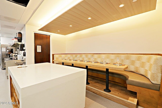 kitchen with backsplash, a kitchen island, and wooden ceiling