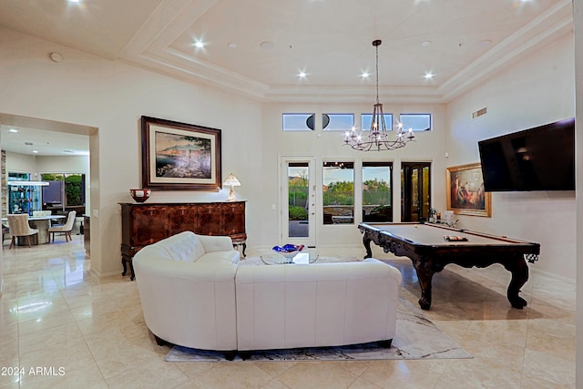 living room featuring a chandelier, a towering ceiling, a raised ceiling, and pool table