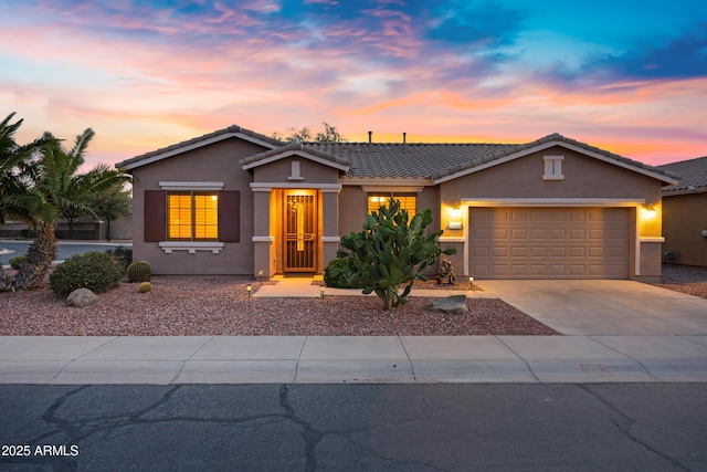 ranch-style house with a garage, stucco siding, a tile roof, and concrete driveway