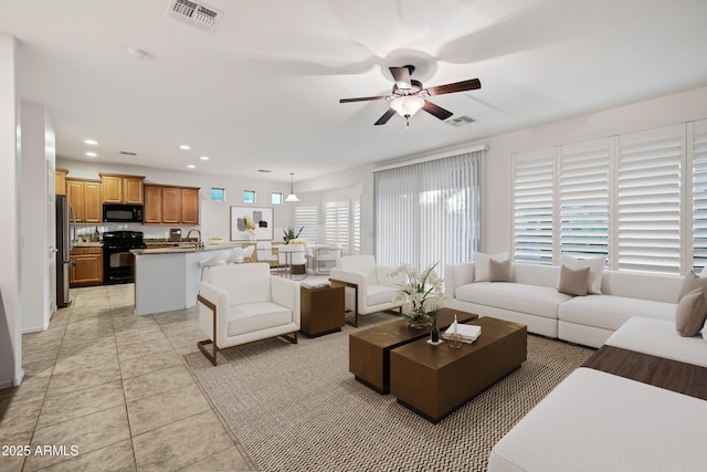 living area with a ceiling fan, visible vents, light tile patterned floors, and recessed lighting