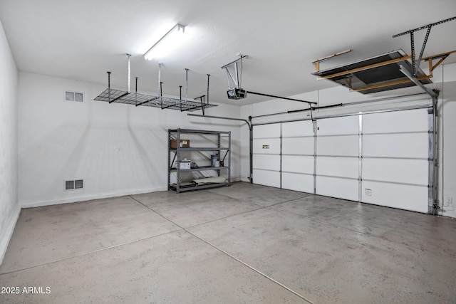 garage with baseboards, visible vents, and a garage door opener