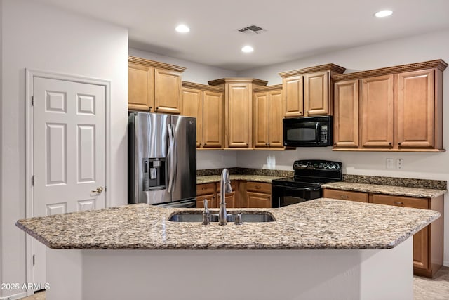 kitchen with light stone counters, a sink, recessed lighting, visible vents, and black appliances