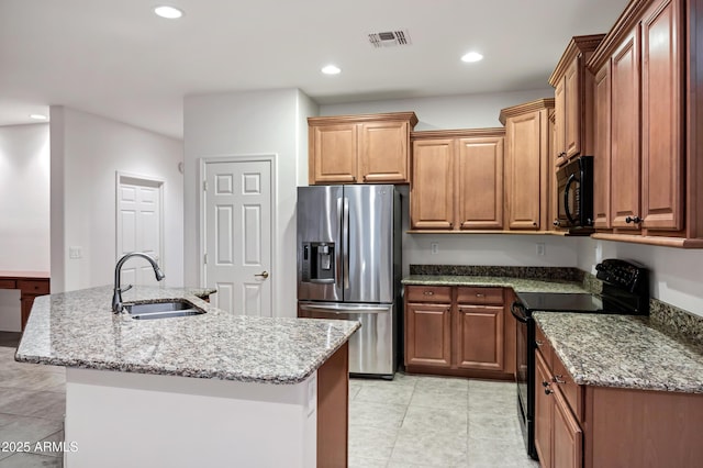 kitchen featuring light stone counters, a sink, light tile patterned floors, and black appliances