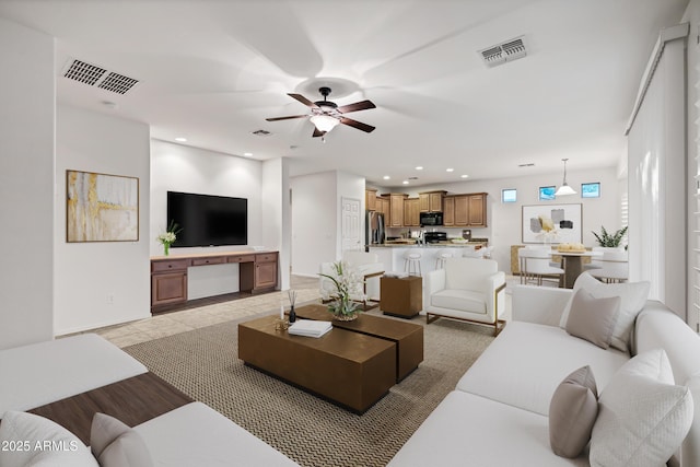 living area with recessed lighting, ceiling fan, and visible vents