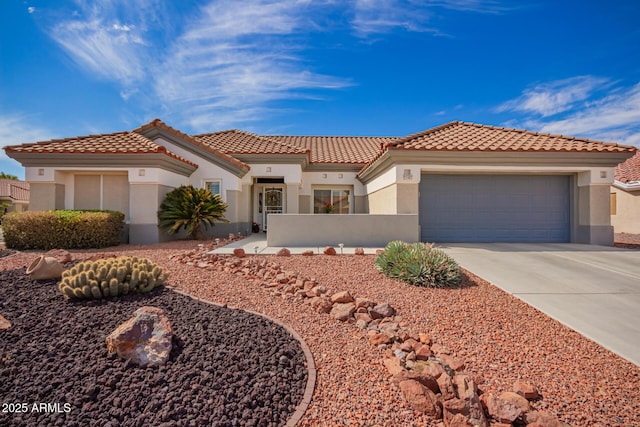 mediterranean / spanish house with a garage, concrete driveway, a fenced front yard, a tiled roof, and stucco siding