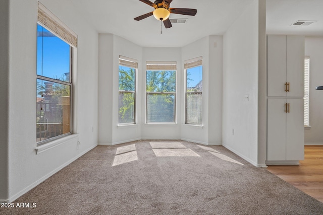 empty room featuring visible vents, baseboards, ceiling fan, and carpet floors