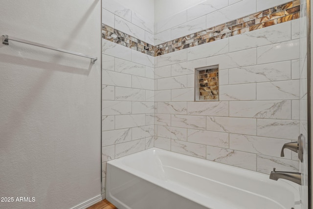 full bath featuring tub / shower combination, baseboards, and a textured wall