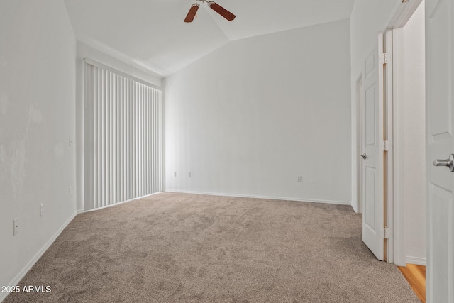 carpeted spare room with baseboards, lofted ceiling, and ceiling fan