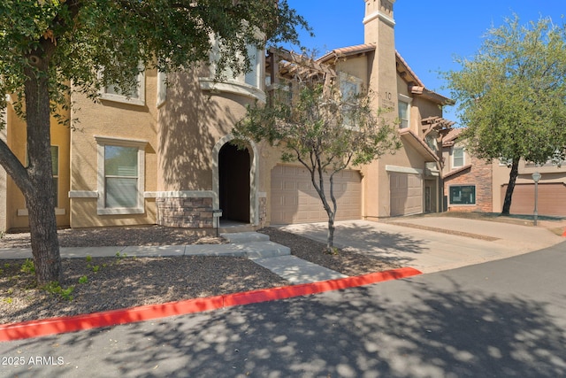 view of front of property featuring stone siding, a garage, driveway, and stucco siding