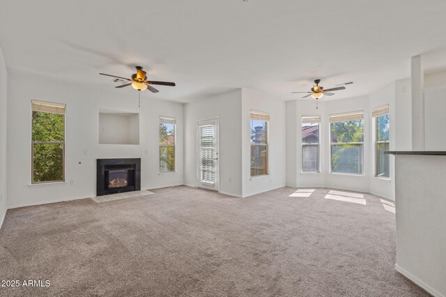 unfurnished living room with plenty of natural light, carpet, and ceiling fan