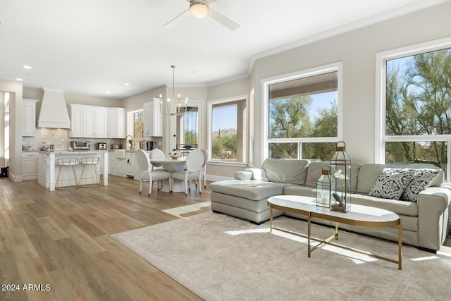 8757 E Lariat Ln, Scottsdale, AZ 85255 - living room with plenty of natural light, light wood finished floors, a chandelier, a ceiling fan, and crown molding