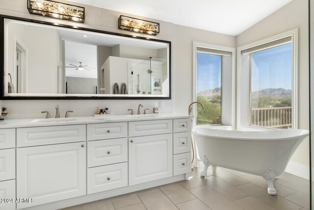 bathroom featuring independent shower and bath, ceiling fan, lofted ceiling, vanity, and tile patterned flooring