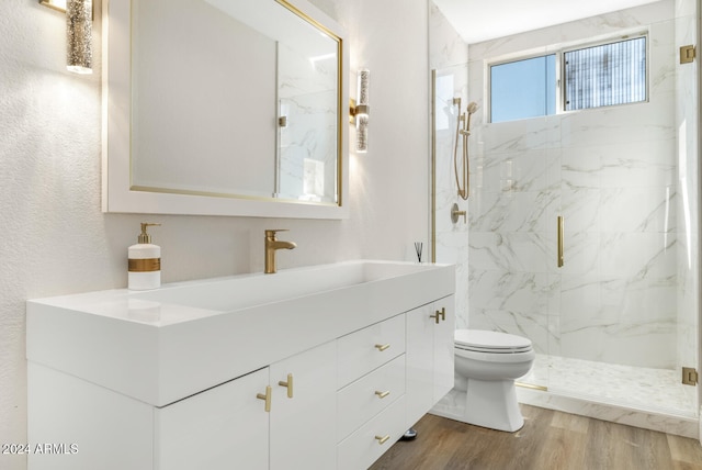 bathroom featuring vanity, hardwood / wood-style floors, walk in shower, and toilet