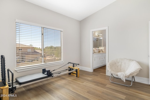 workout area with light hardwood / wood-style floors and lofted ceiling