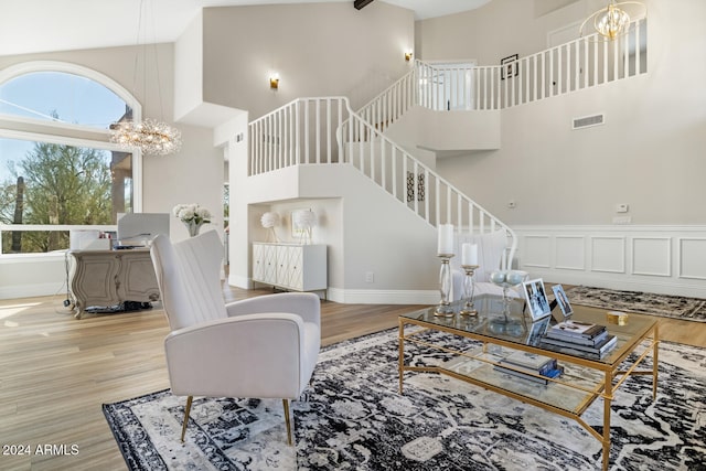 living room featuring a notable chandelier, high vaulted ceiling, and light hardwood / wood-style flooring