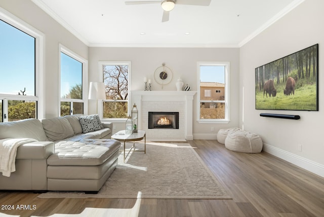 living room featuring light hardwood / wood-style floors, a healthy amount of sunlight, crown molding, and ceiling fan