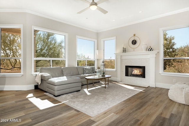 living room with a wealth of natural light, ornamental molding, and wood-type flooring