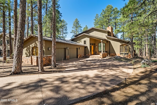2096 William Palmer, Flagstaff, AZ 86005 - view of front of house with an attached garage, stone siding, a chimney, and concrete driveway