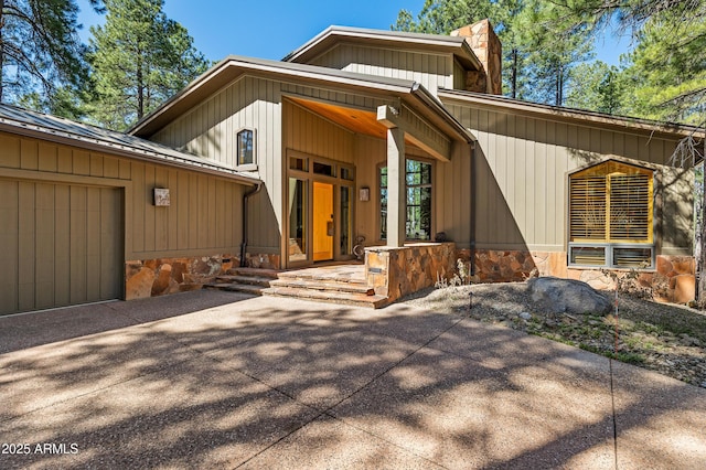 2096 William Palmer, Flagstaff, AZ 86005 - doorway to property featuring covered porch, an attached garage, a chimney, and stone siding