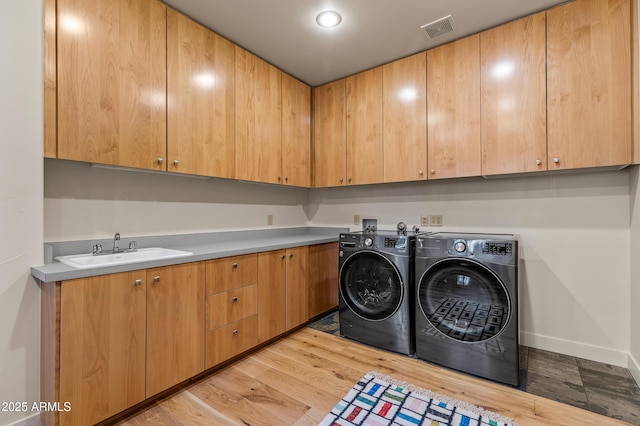 2096 William Palmer, Flagstaff, AZ 86005 - laundry room with visible vents, light wood-style flooring, washing machine and clothes dryer, a sink, and cabinet space